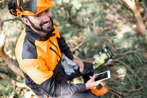 Expert from one of the top tree companies in Monmouth County, Ben Bivins Tree Experts, with phone in hand